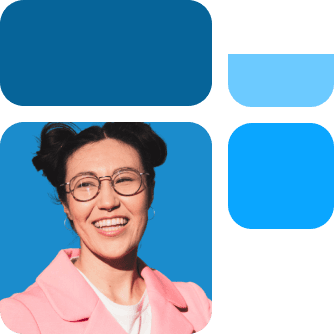 Eine Frau mit Brille und doppelter Duttfrisur lächelt, trägt einen rosa Mantel, vor einem blauen Hintergrund mit blauen geometrischen Formen.